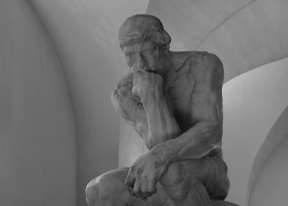 Statue A carved statue of a person resting their head on the fist